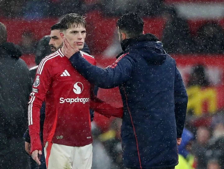 Manchester United's Alejandro Garnacho being consoled by a coach.