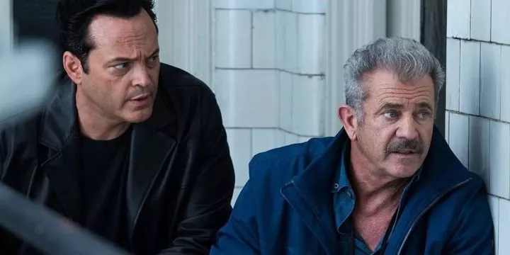 Mel Gibson and Vince Vaughn hiding behind a wall in Dragged Across Concrete.