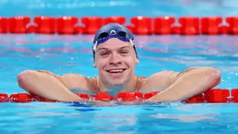 Getty Images  Léon Marchand smiles to the camera from the pool