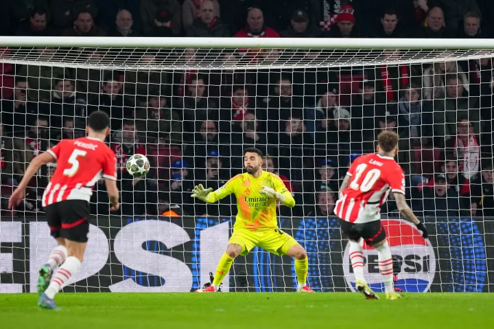 Noa Lang scoring a penalty goal during a PSV vs Arsenal soccer match.