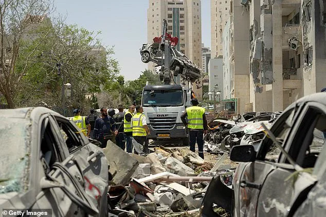 Workers clean up debris near a building in Beersheba, Israel where four people were killed by an Iranian missile strike. According to Israeli authorities, Iran launched a barrage of missiles in the early hours Tuesday including several missiles after the ceasefire was to take place