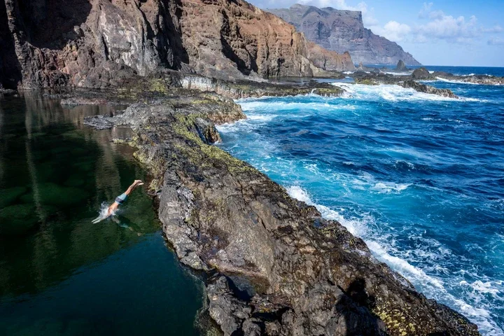 Image may contain Cliff Nature Outdoors Rock Leisure Activities Person Sport Swimming Water Water Sports and Adult