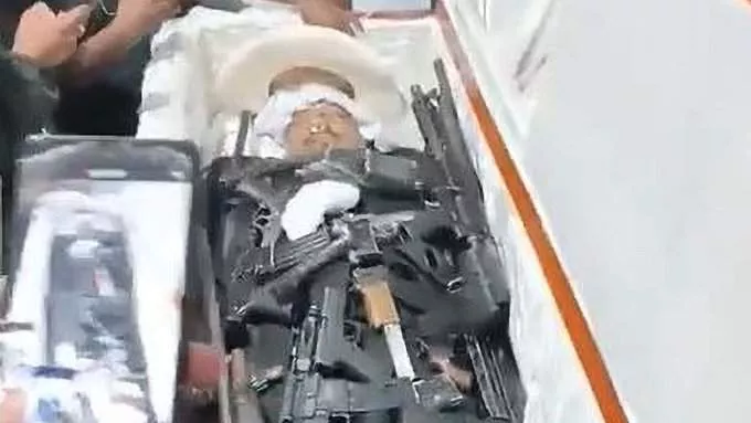 Moment drug Cartel baron is buried with lots of machine guns so he can 