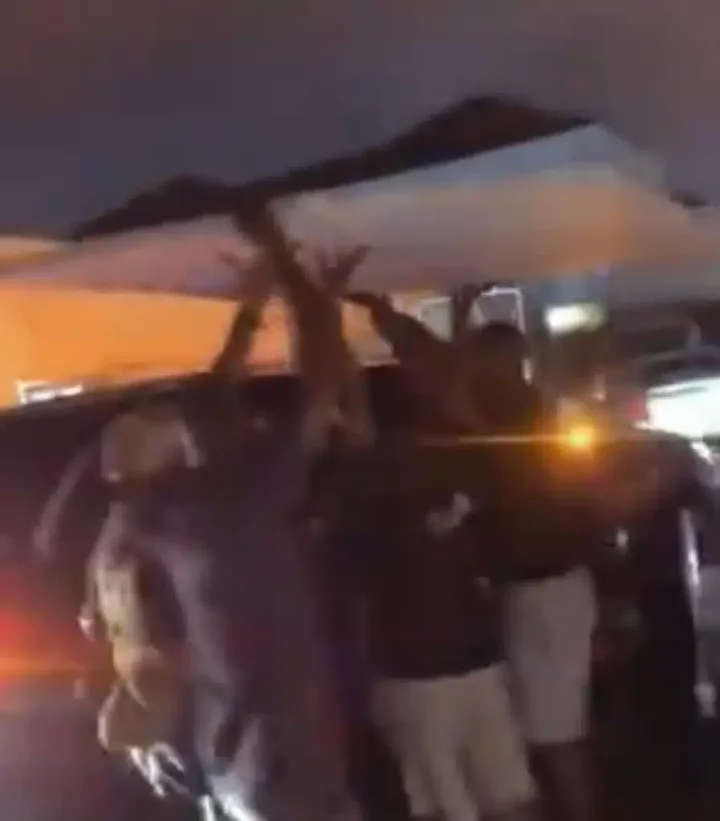 Reactions as men seen shielding Wizkid from rain with plank (Video)
