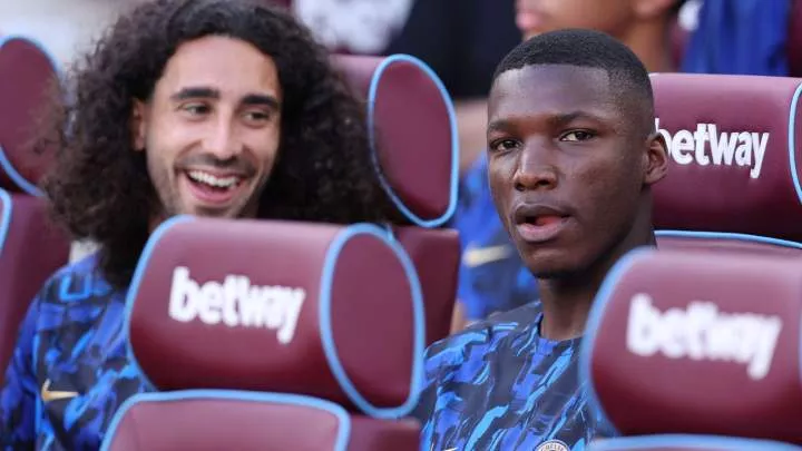 Moises Caicedo and Marc Cucurella sit on the bench before a game.