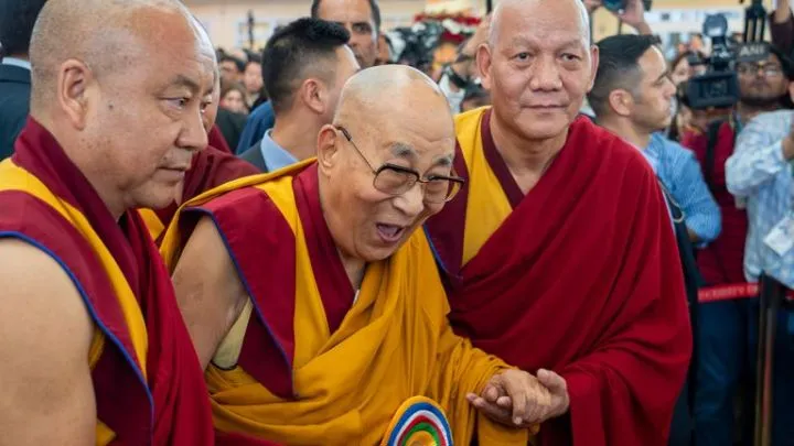 Monks aid the Dalai Lama during his 90th birthday celebrations on 30 June. Pic: AP
