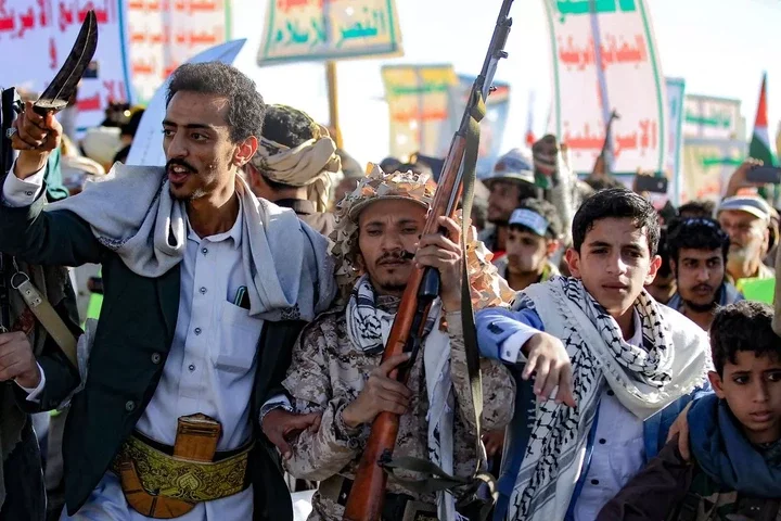 A Houthi fighter carries a rifle as Yemenis rally to denounce Israel