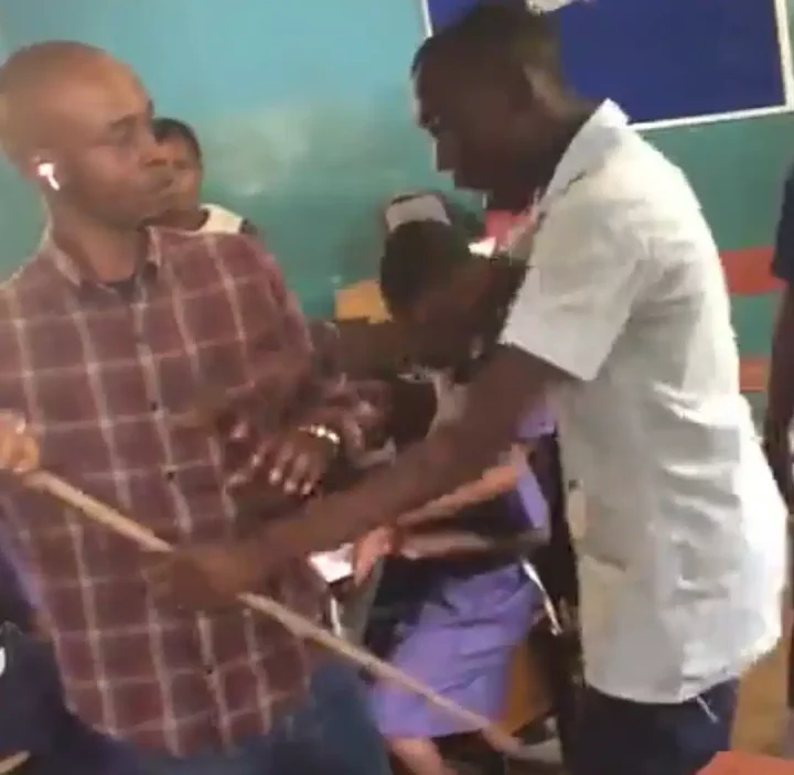 'E go repeat that class' - Student generates buzz online as he challenges male teacher, wrestles cane with him