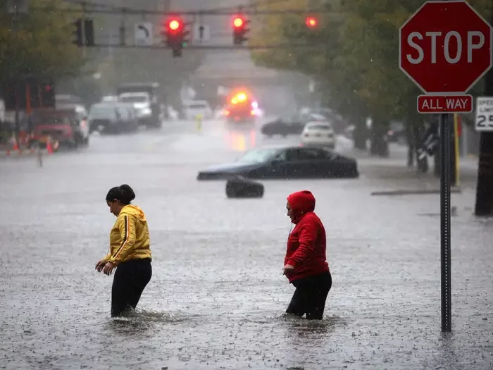Residents walk through floodwaters during a heavy rain storm in the New York City suburb of Mamaroneck in Westchester County, New York, U.S., September 29, 2023.