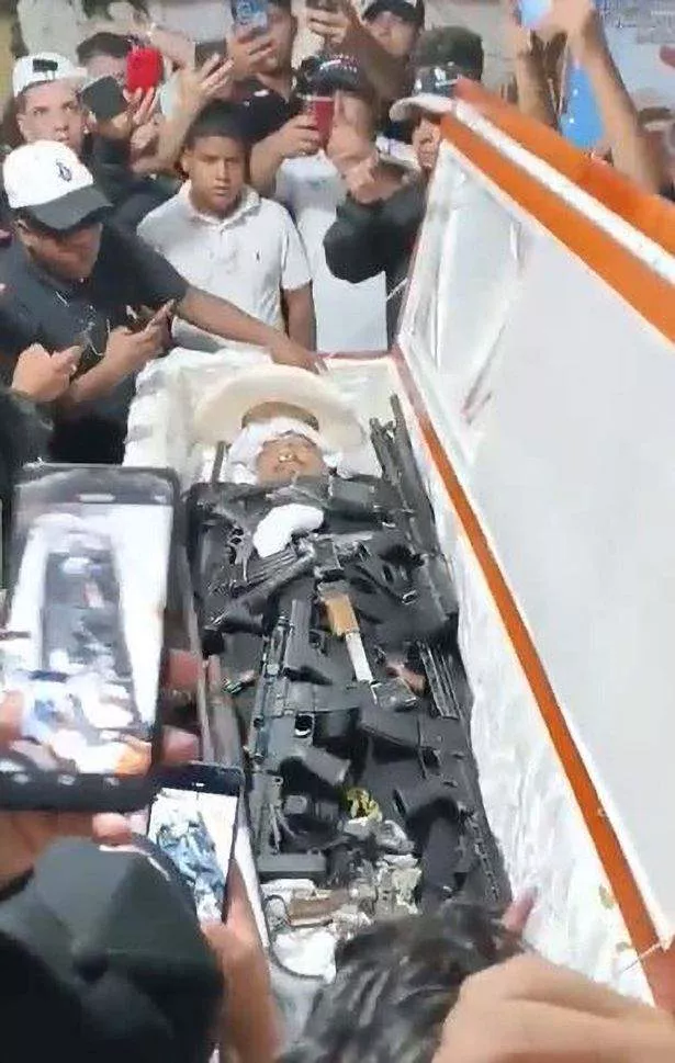 Moment drug Cartel baron is buried with lots of machine guns so he can 