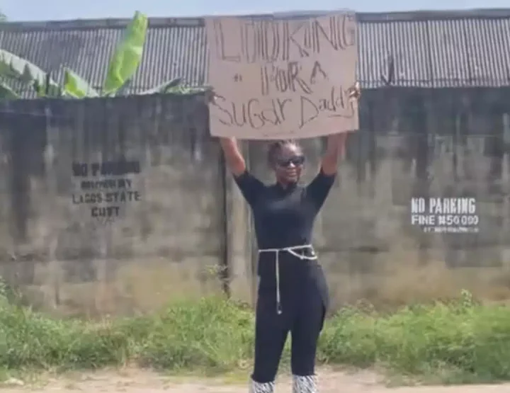 'Looking for sugar daddy' - Lady in search for rich sugar daddy storms street with placard, gives number to men