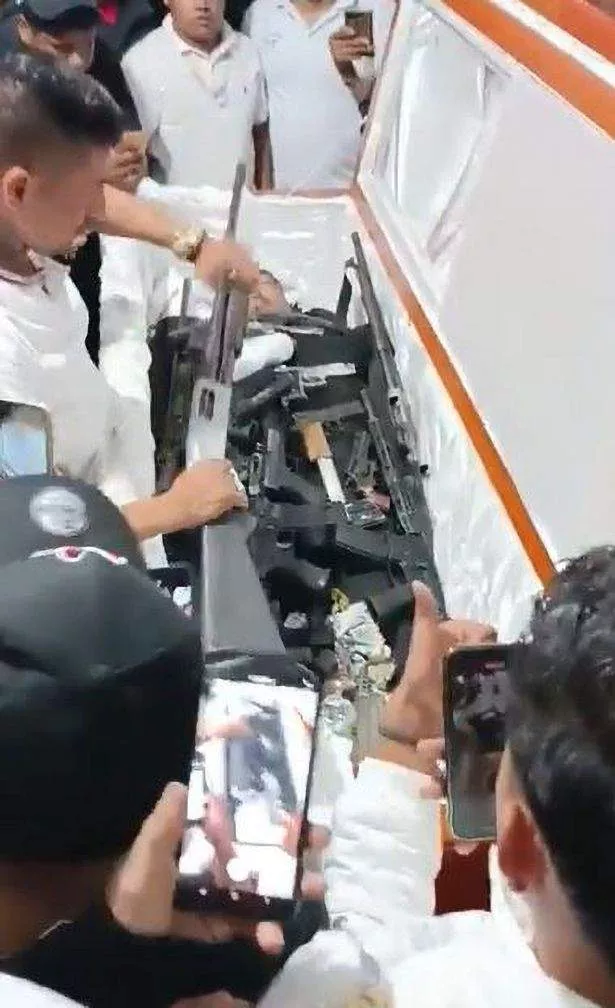 Moment drug Cartel baron is buried with lots of machine guns so he can 
