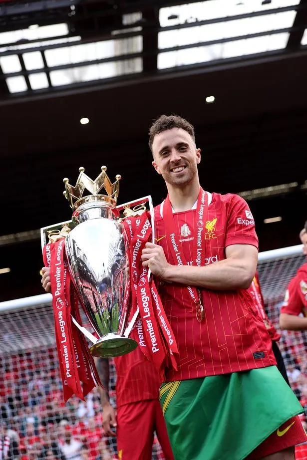 Diogo Jota poses for a photograph with the Premier League trophy he helped bring back to Liverpool