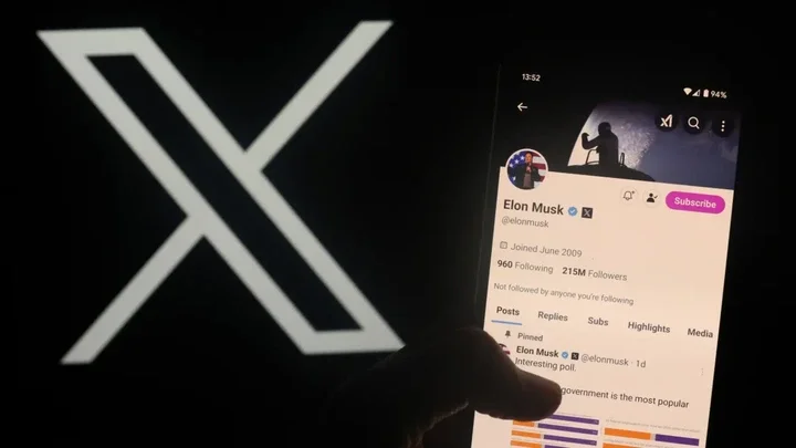 a user holds up phone showing elon musk's x feed in front of x logo