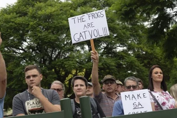 White South Africans demonstrate in support of U.S. President Donald Trump in front of the U.S. embassy in Pretoria, South Africa, Saturday, Feb. 15, 2025. (AP Photo/Jerome Delay)