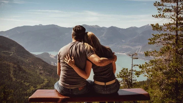 couple holding one another over cliff