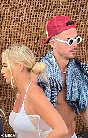 The Man City star walks off with his shirt draped around his neck and puts on a pair of sunglasses