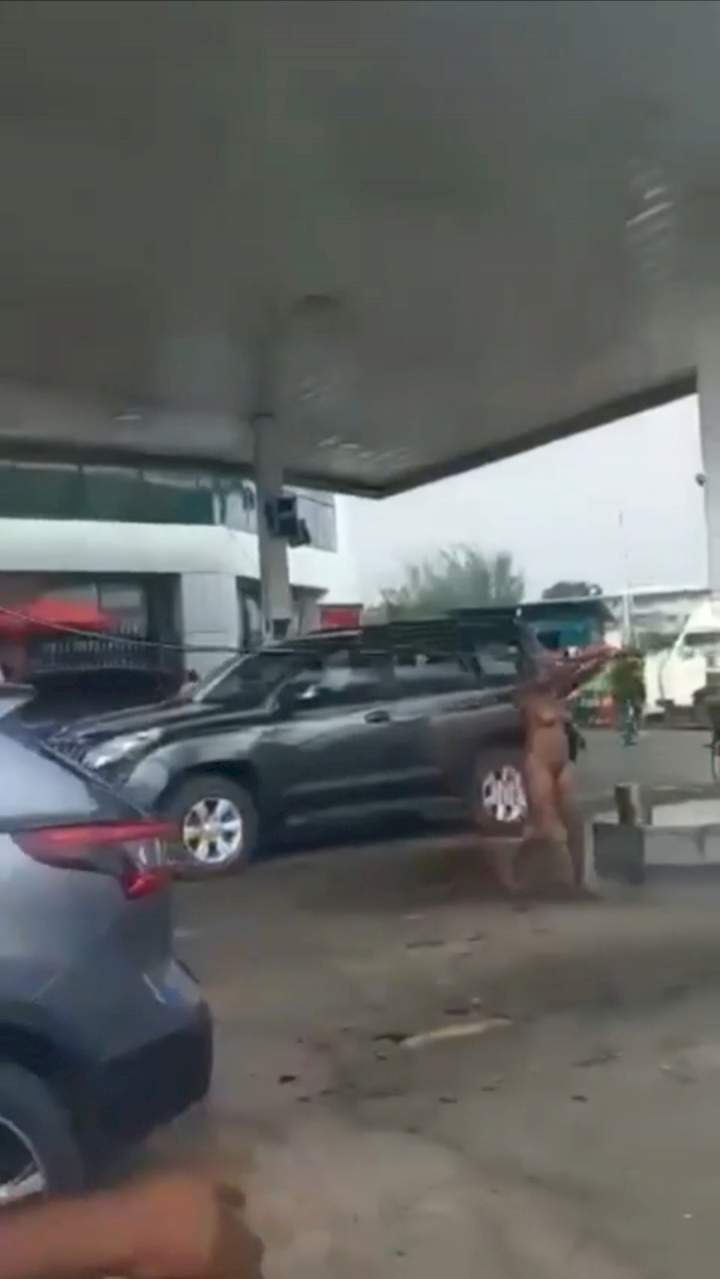 Naked woman causes chaos as she hijacks fuel pump and sprays petrol on customers at petrol station in Falomo, Ikoyi (video)