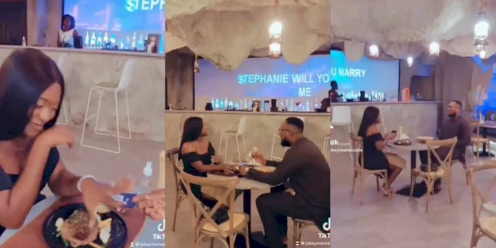 Reactions as man sits on chair to propose to girlfriend in restaurant (Video)