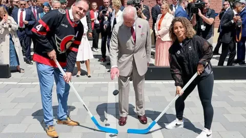 Getty Images  King Charles III drops the puck to launch the hockey match at a community event in Lansdowne Park during an official visit to Canada on May 26, 2025 in Ottawa, Ontario. 