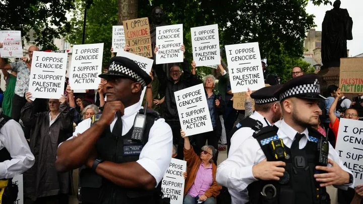 PA Media People holding signs and placards in support of Palestine Action, surrounded by police PA Media People holding signs and placards in support of Palestine Action, surrounded by police