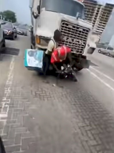 Dispatch rider almost crushed by truck while collecting money from Naira Marley (Video)