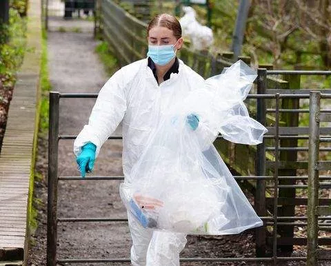 An officer carrying material from the scene CREDIT: Peter Byrne/pa (Telegraph)