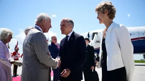 PA Media King Charles III is greeted by Canadian Prime Minister Mark Carney and Diana Fox Carney