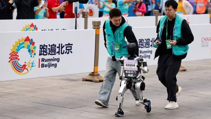 Engineers run with one robot. Pic: Reuters