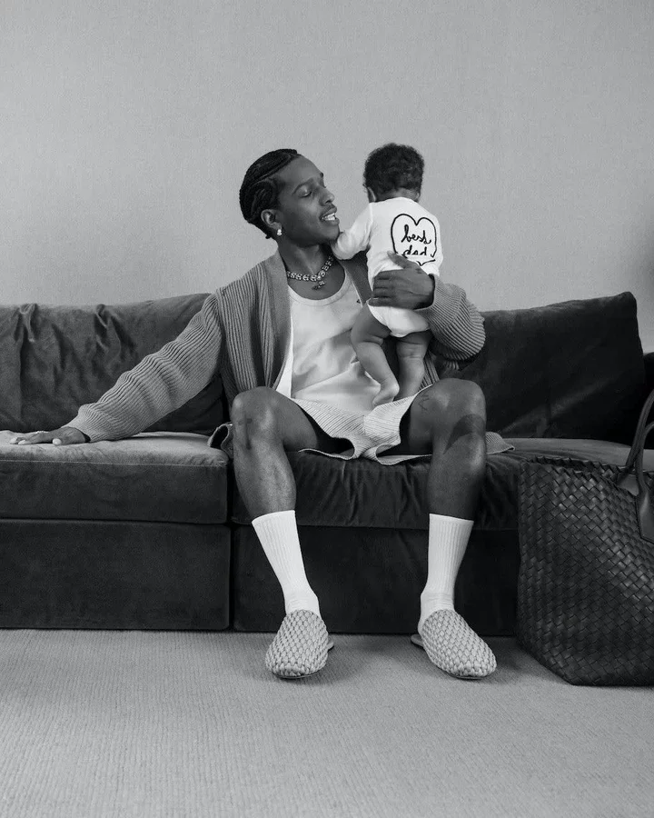 a man sitting on a couch holding a baby