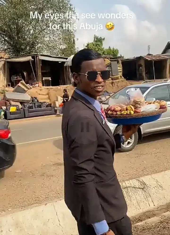 'Even kola man don rebrand' - Man rocks suit to sell kola nuts on Abuja streets