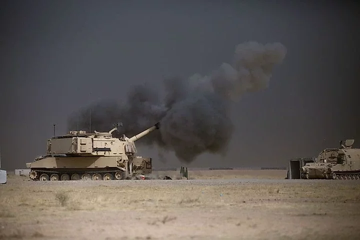 A U.S. Army M109A6 Paladin conducts a fire mission during the Battle of Mosul. Image in Public Domain via US Army.