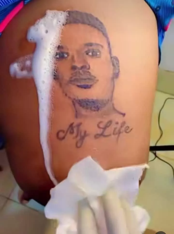 Lady tensions singles as she tattoos boyfriend's face on her lap