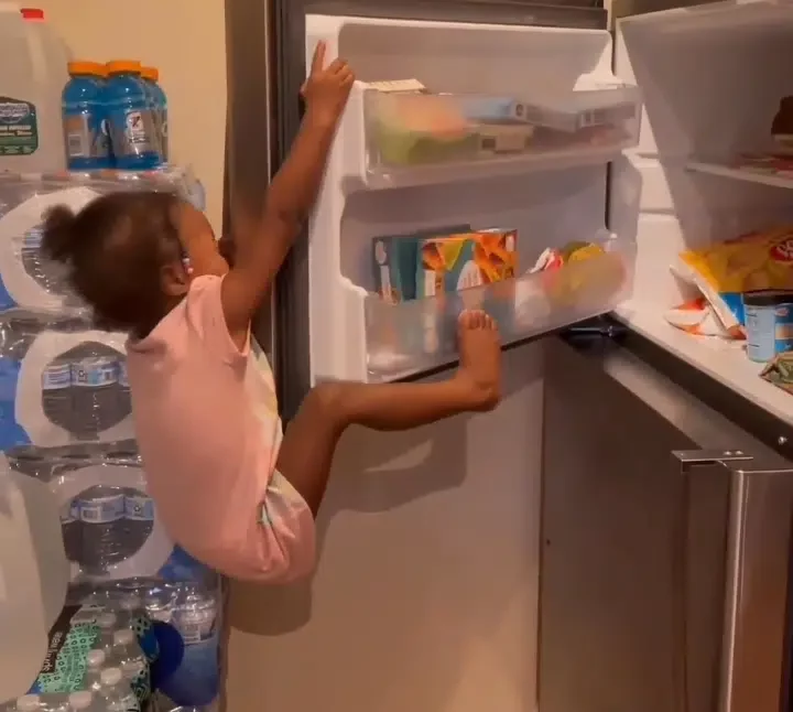 Scary moment a little girl climbed fridge to steal snacks and got stuck (Video)