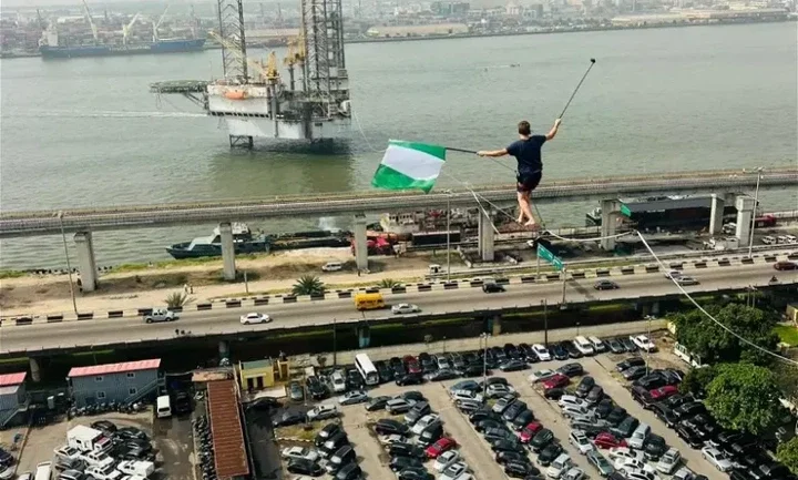 Video: Man captured walking on rope across bridge, train tracks in Lagos