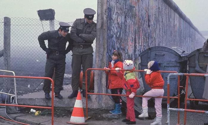 West German School Children Pause To Talk With Two East German Border Guards Beside An Opening In The Berlin Wall During The Collapse Of Communism In East Germany In November 1989 (Photo: Stephen Jaffe)