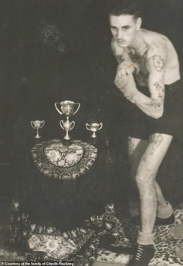 Charlie Hackney seen in a boxing pose with a series of trophies