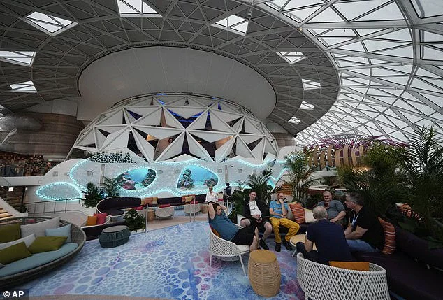Passengers lounge in the Aquadome area of Icon of the Seas, a diving and performance venue under a glass dome on the top of the ship