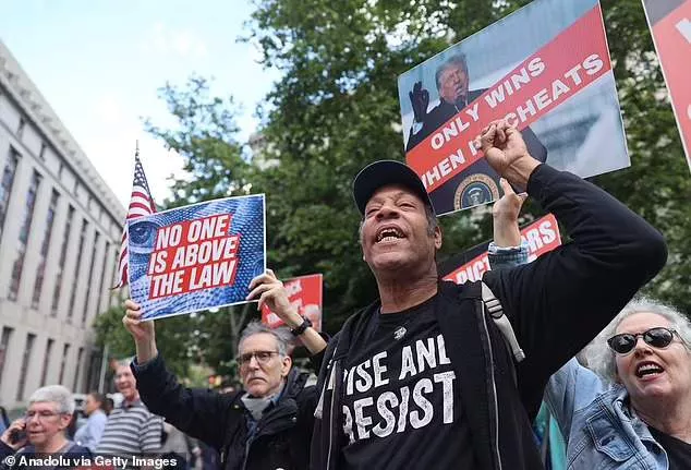 Anti-Trump demonstrators gather with banners following Trump's hush money trial verdict