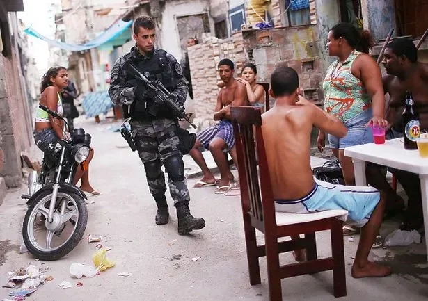 A Brazilian military police officer patrols after entering the unpacified Complexo da Mare, one of the largest 'favela' complexes in Rio