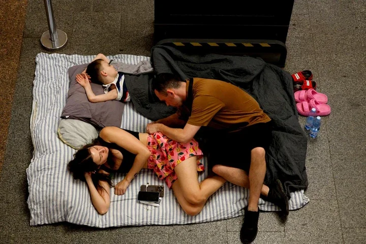 A family tries to sleep while sheltering inside a metro station during an air raid alert amid Russia's attack on Ukraine, in Kyiv, Ukraine, July 8, 2025.