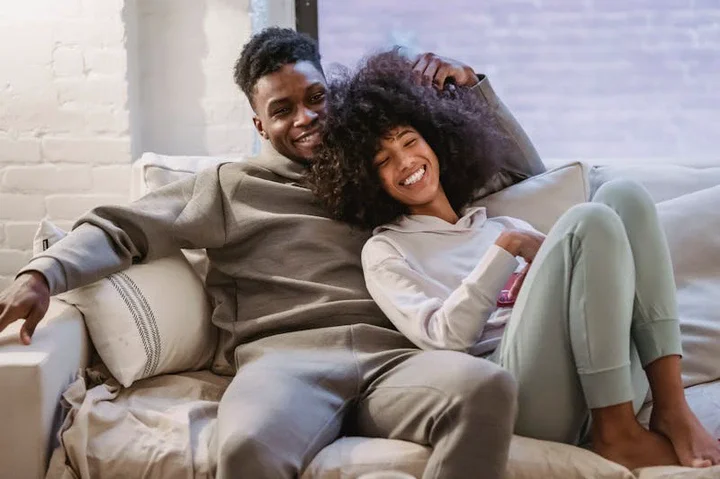 Couple cuddling on a sofa at home, showing emotional safety and comfort in a close relationship