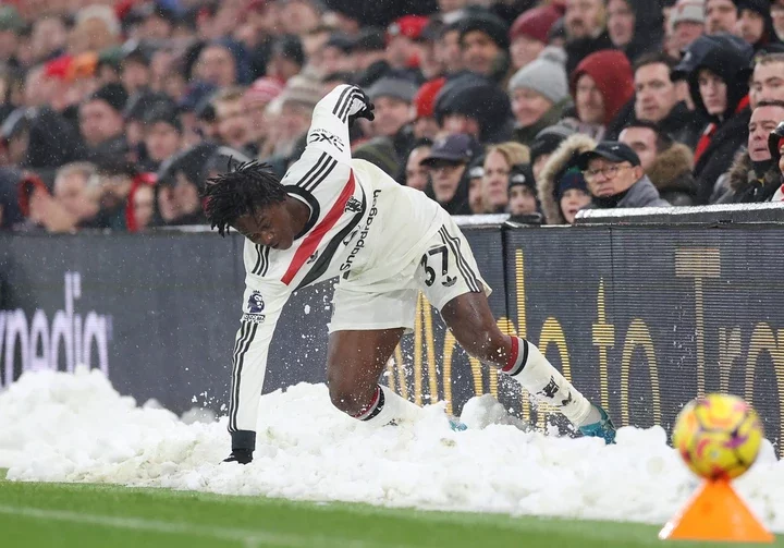 Kobbie Mainoo of Manchester United slips in the snow during the Premier League match between Liverpool FC and Manchester United FC at Anfield on Ja...