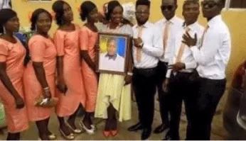 Lady causes stir as she marries photo of lover who claimed to be too busy for wedding