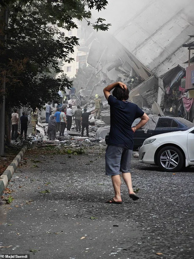 A person reacts as residential buildings in Nobonyad Square are shown following Israeli airstrikes on June 13