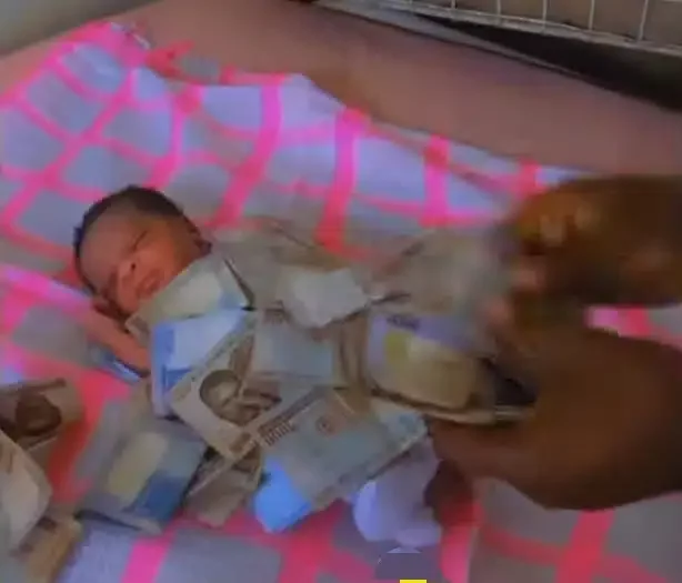 Nigerian big boy who just became a father sprays money on his newborn baby (Video)