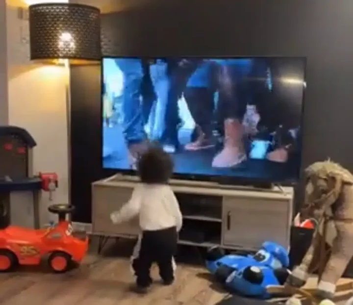 Happy toddler stomps foot, dances to Burna Boy's 'City Boys' music video showing on TV, causes stir online