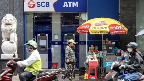 Getty Images Motorbikes speed past a branch of Saigon Commercial Bank (SCB) in Ho Chi Minh City, Vietnam, on Wednesday, April 17, 2024.