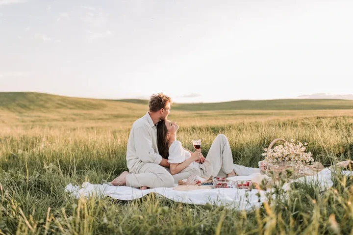 Couple having a romantic picnic, lying on grass, enjoying a peaceful moment together