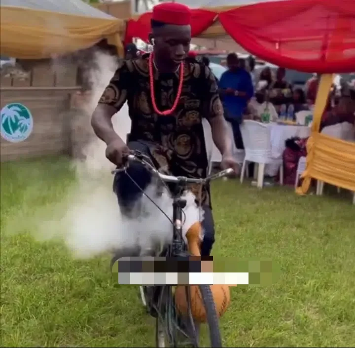 Man makes grand entrance into wedding reception with bicycle and calabash displaying white smoke (Video)